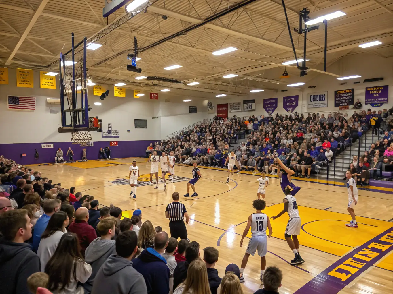 A dynamic image of students engaged in a basketball game inside a modern gymnasium, with players jumping for a rebound and spectators cheering, illustrating active participation and excitement.